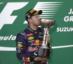 Red Bull Formula One driver Sebastian Vettel of Germany kisses his trophy after winning the Japanese F1 Grand Prix at the Suzuka circuit October 13, 2013. REUTERS/Toru Hanai (JAPAN - Tags: SPORT MOTORSPORT F1)