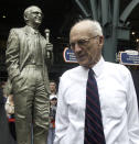 FILE - In this Sept. 15, 2002 file photo, Detroit Tigers Hall of Fame broadcaster Ernie Harwell pauses near a statue honoring him that was unveiled inside the entrance to Comerica Park in Detroit. Their voices are the backdrop to all those warm summer nights. Their distinctive calls are part of the game’s lore. Fans visualize the action through their stories and descriptions. (AP Photo/Paul Sancya, File)