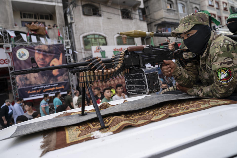 A Hamas militant holds a squad automatic weapon perched atop a truck during a parade through the streets for Bassem Issa, a top Hamas' commander, who was killed by Israeli Defense Force military actions prior to a cease-fire reached after an 11-day war between Gaza's Hamas rulers and Israel, in Gaza City, Saturday, May 22, 2021. (AP Photo/John Minchillo)