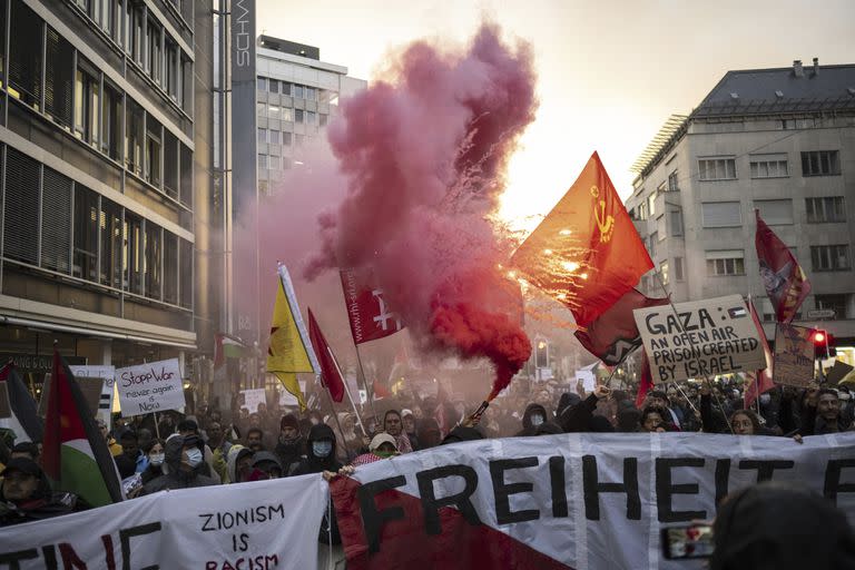 Protesters hold placards and Palestinian flags despite a ban on demonstrations during a rally in support of Palestinians in Zurich, Switzerland, Friday, Oct. 20, 2023. (Ennio Leanza/Keystone via AP)