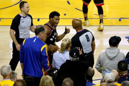 Toronto's Kyle Lowry complains to referee Marc Davis after being pushed by Golden State Warriors minority investor Mark Stevens during an NBA Finals game Wednesday