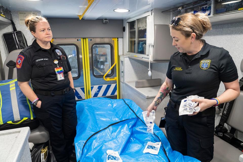 Medic Cassandra Lydon, left, and Capt. Christa Stedman demonstrate how to cool down a patient suffering from heat exhaustion using ice packs and a cooling tarp in an Austin-Travis County EMS ambulance recently.