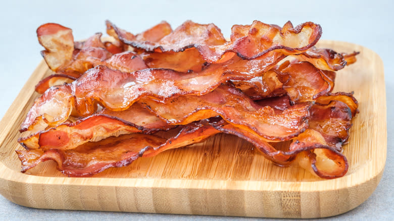 crispy bacon strips on wood plate