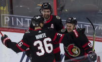 Ottawa Senators center Colin White and left-wing Nick Paul (center) congratulate right wing Evgenii Dadonov on his game-winning goal during the third period of an NHL game Monday, April 12, 2021, in Ottawa, Ontario. (Adrian Wyld/The Canadian Press via AP)