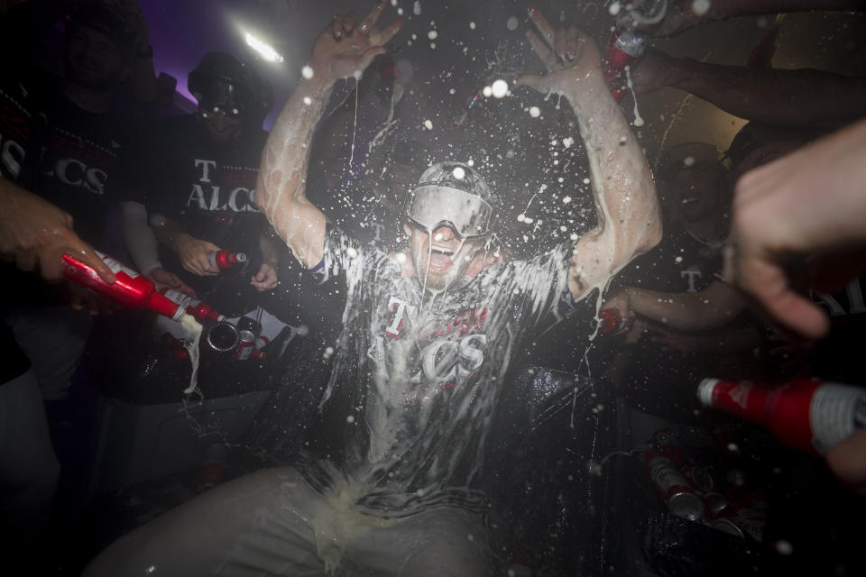 Nathan Eovaldi, abridor de los Rangers de Texas, festeja con sus compañeros tras ganar la serie divisional de la Liga Americana frente a los Orioles de Baltimore, el martes 10 de octubre de 2023 (AP Foto/Julio Cortez)