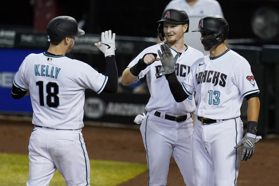 Arizona Diamondbacks' Carson Kelly (18) celebrates hit three-run home run against the Texas Rangers with Pavin Smith, middle, and Nick Ahmed (13) during the sixth inning of a baseball game Tuesday, Sept. 22, 2020, in Phoenix. (AP Photo/Ross D. Franklin)