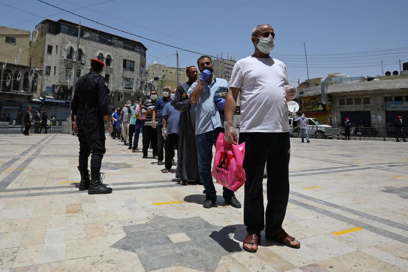 Muslims stand in line before taking part in Friday prayers at al Husseini mosque in Amman