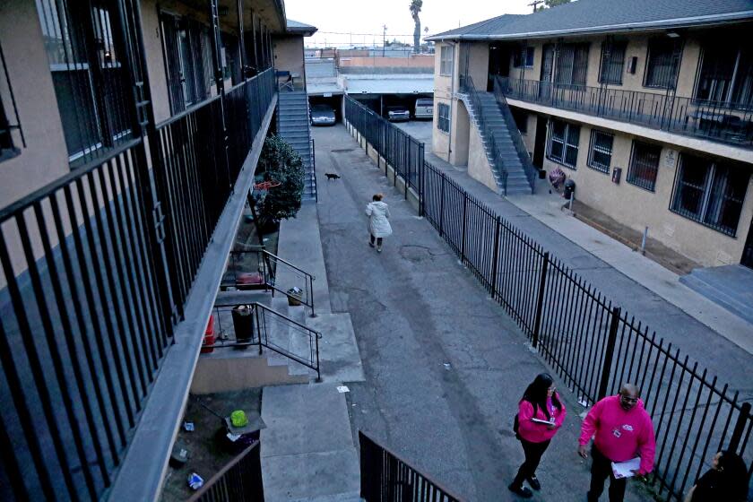 LOS ANGELES, CA - JANUARY 18: Bianca Lopez, 25, left, an outreach worker, and La Bomba Jackson, coordinator, with We Are Los Angeles, a project of the Mayor's Fund for Los Angeles, shown with Maria Amezquita, of the Mayor's Fund for Los Angeles, far right, inform tenants of their rights at an apartment complex on Thursday, Jan. 18, 2024 in Los Angeles, CA. The Mayor's Fund for Los Angeles, a nonprofit closely associated with City Hall, shifted its focus last year to preventing homelessness through preventing evictions. Outreach workers who visit neighborhoods across Los Angeles where tenants are at risk of eviction and seek to connect those tenants with information and resources to help them keep their homes. (Gary Coronado / Los Angeles Times)