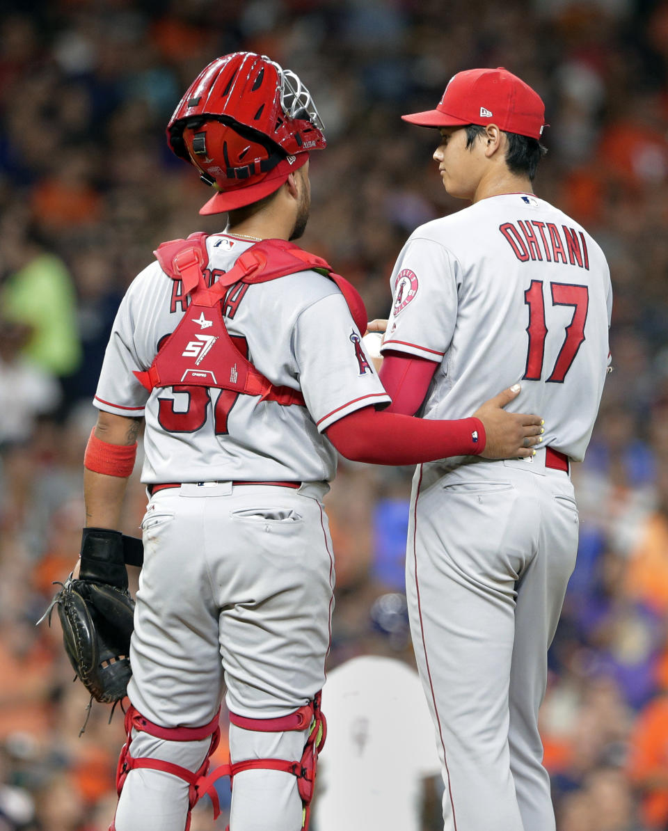 Los Angeles Angels catcher Francisco Arcia (37) talks with starting pitcher Shohei Ohtani (17) as he waits to be pulled during the third inning of a baseball game against the Houston Astros Sunday, Sep. 2, 2018, in Houston. (AP Photo/Michael Wyke)
