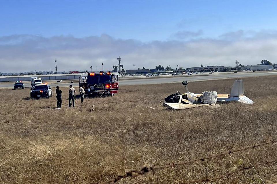 This photo provided by KION-TV shows multiple agencies responding to Watsonville Municipal Airport, northwest of Watsonville, in Santa Cruz County, Calif. after 2 planes attempting to land collided on Thursday, Aug. 18, 2022. Two planes collided in Northern California while trying to land at a local airport and at least two of the three occupants were killed. (KION-TV via AP)