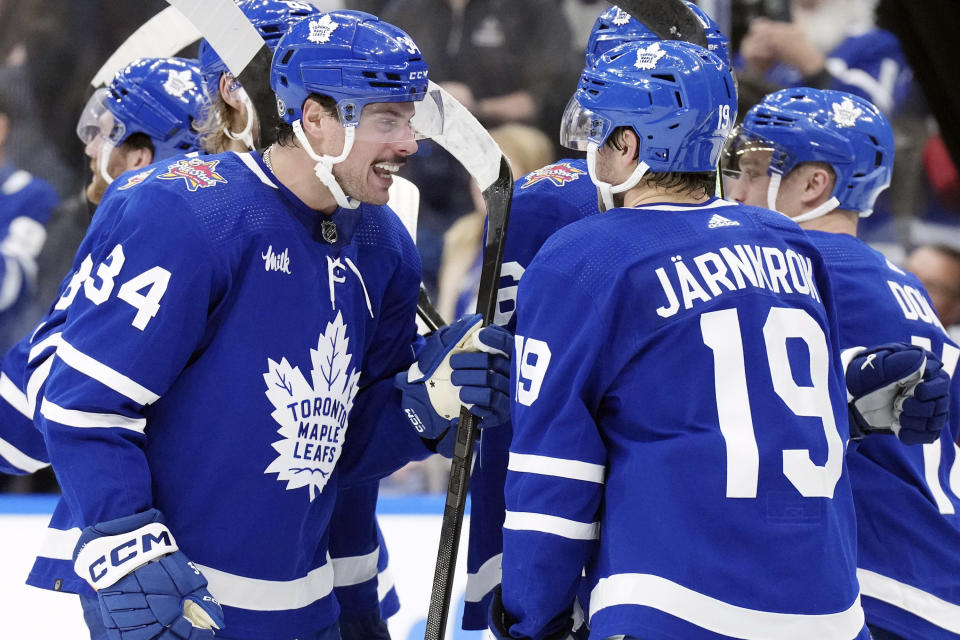 Toronto Maple Leafs' Auston Matthews (34) congratulates center Calle Jarnkrok (19) after Jarnkrok scored the overtime winning goal against the Tampa Bay Lightning in NHL hockey game action in Toronto, Monday, Nov. 6, 2023. (Chris Young/The Canadian Press via AP)