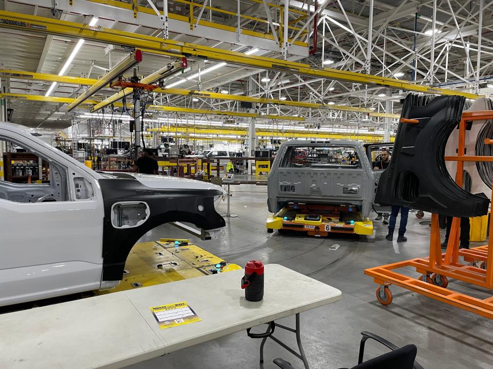 Partially built F-150 Lightning cabs move on automated pallets down the assembly line.