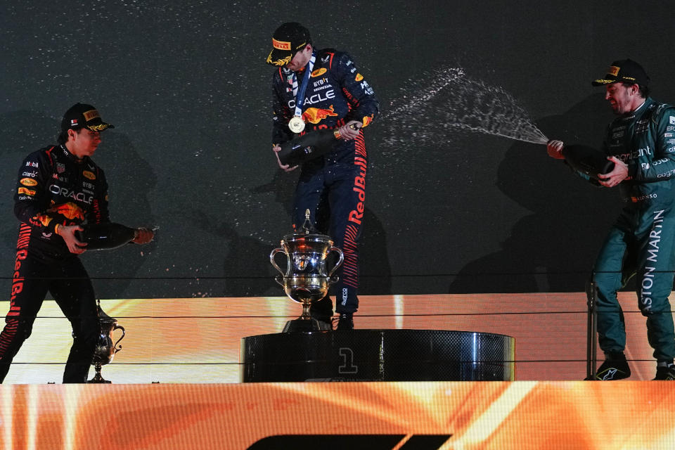 Desde la izquierda, Sergio Pérez, Max Verstappen y Fernando Alonso celebran en el podio del Gran Premio de Bahréin, el domingo 5 de marzo de 2023. (AP Foto/Ariel Schalit)