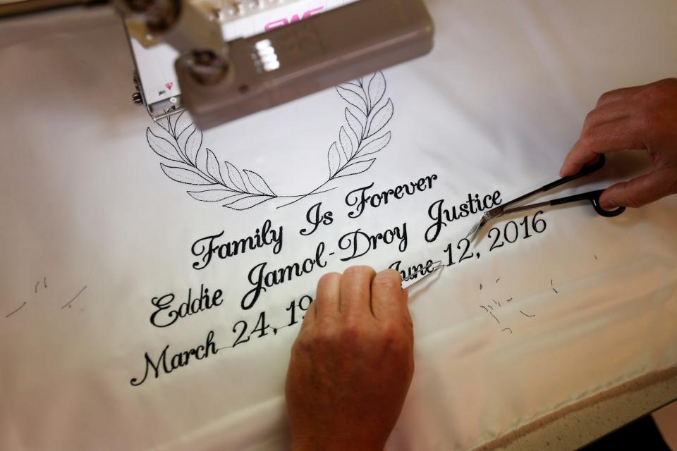 <p>A worker at Cardinal Casket Co. trims a piece of embroidery for a casket before the funeral of Pulse night club shooting victim Eddie Justice in Orlando, Florida, U.S., June 21, 2016. (REUTERS/Carlo Allegri) </p>