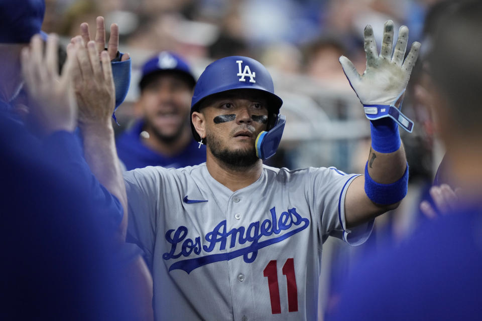 Los Angeles Dodgers' Miguel Rojas (11) celebrates with teammates after he scored on a single by Will Smith during the third inning of a baseball game against the Miami Marlins, Tuesday, Sept. 5, 2023, in Miami. (AP Photo/Wilfredo Lee)