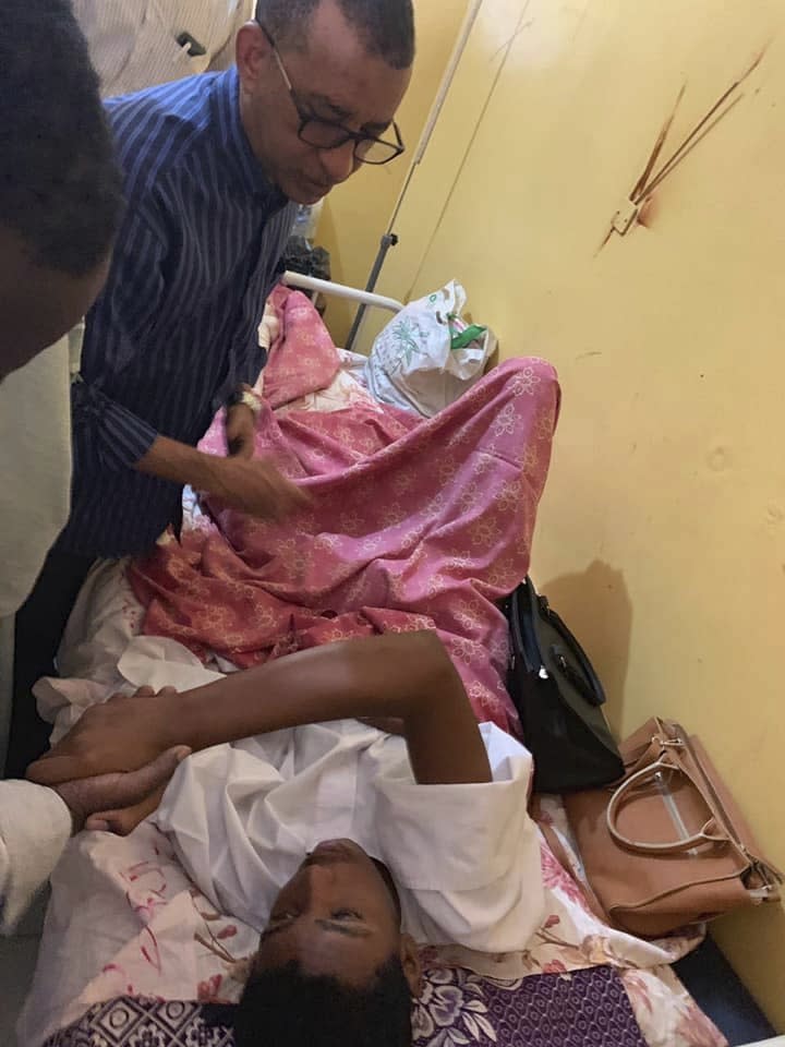 This Monday, July 29, 2019 image provided by the Sudanese Congress Party, shows Omar al-Dagir, head of the Sudanese Congress Party, visiting a wounded demonstrator in a hospital in Obeid, North Kordofan province, Sudan, . Thousands of Sudanese students have taken to the streets in the capital and elsewhere in the country to condemn violence against fellow students. (Sudanese Congress Party via AP)