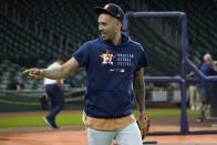 Houston Astros' Carlos Correa talks with media members standing nearby as he walks out onto the field for baseball practice in Houston, Thursday, Oct. 14, 2021. The Astros host the Boston Red Sox in Game 1 of the American League Championship Series on Friday. (AP Photo/Tony Gutierrez)