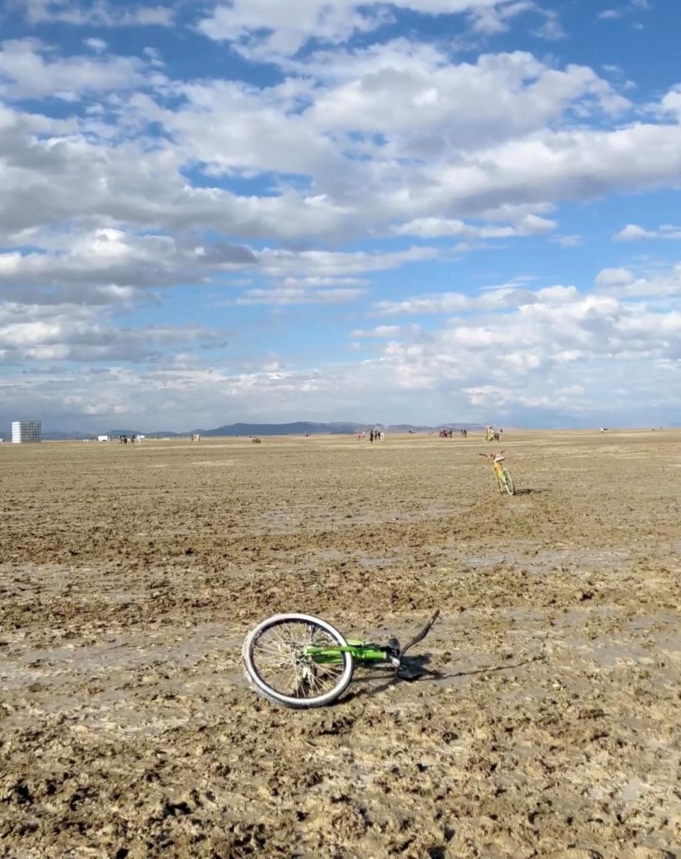 Una bicicleta tirada en el terreno embarrado durante el evento Burning Man.
