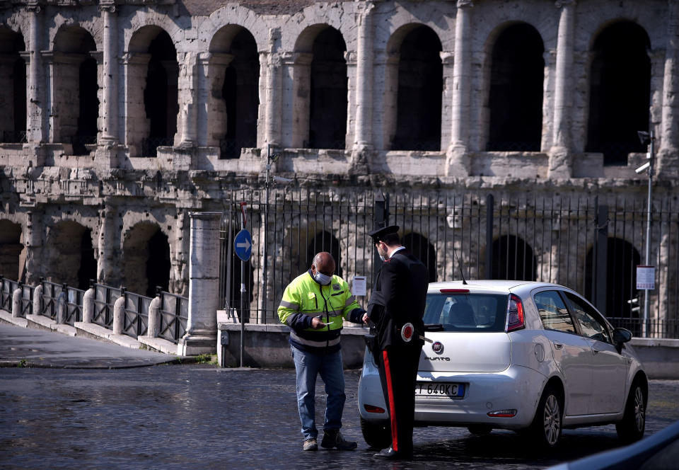 Image: An Italian Carabiniere controls a driver by the Teatro di Marcello in Rome on April 8, 2020 during the country's lockdown aimed at curbing the spread of the COVID-19, caused by the novel coronavirus. (Filippo Monteforte / AFP - Getty Images)