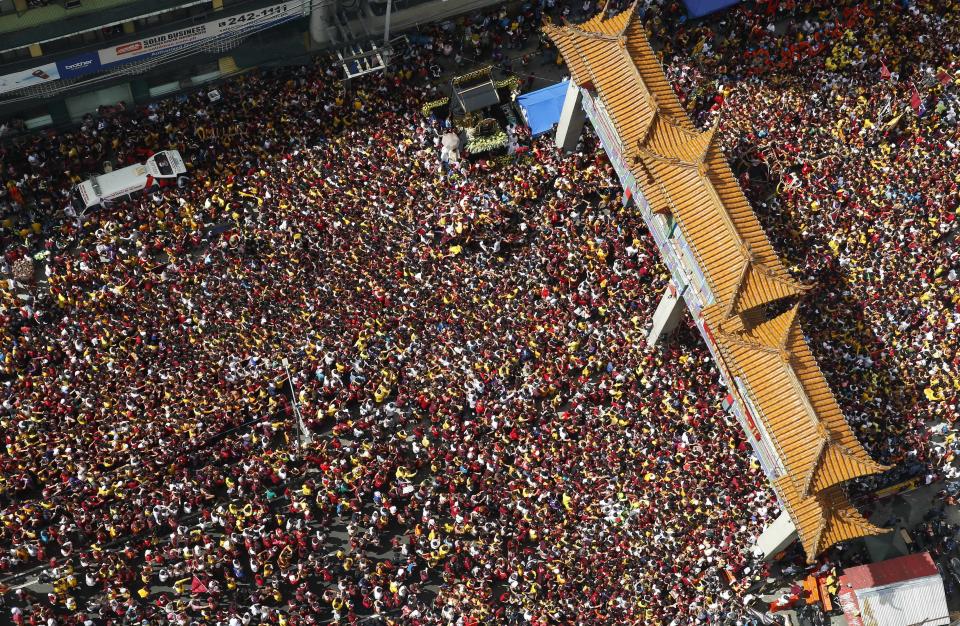A massive crowd of Filipino Roman Catholic devotees follow the carriage