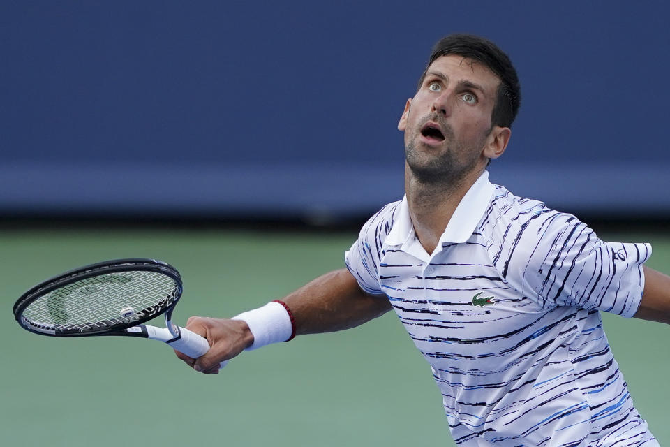 Novak Djokovic, of Serbia, looks to return the ball to Daniil Medvedev, of Russia, during the Western & Southern Open tennis tournament Saturday, Aug. 17, 2019, in Mason, Ohio. (AP Photo/John Minchillo)