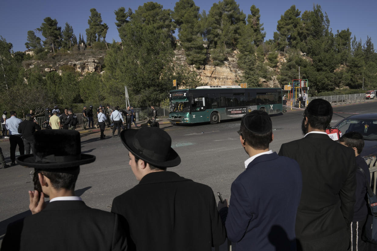 People look at the scene of an explosion at a bus stop in Jerusalem.