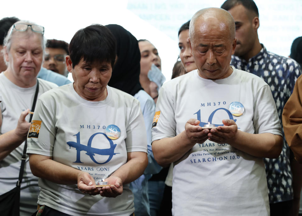 Family members and relatives of passengers on board of the missing Malaysia Airlines Flight 370 stand for a moment of silence during the tenth annual remembrance event at a shopping mall, in Subang Jaya, on the outskirts of Kuala Lumpur, Malaysia, Sunday, March 3, 2024. Ten years ago, a Malaysia Airlines Flight 370, had disappeared March 8, 2014 while en route from Kuala Lumpur to Beijing with over 200 people on board. (AP Photo/FL Wong)