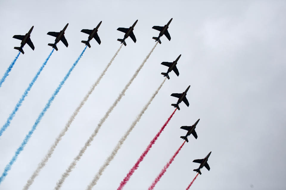 French Alpha jets of the Patrouille de France spray lines of smoke in the colors of the French flag over the Champs-Elysees during Bastille Day parade Sunday, July 14, 2019 near the Champs Elysees avenue in Paris. (AP Photo/Rafael Yaghobzadeh)