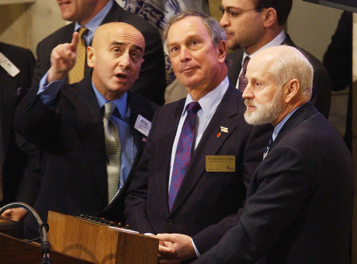 NEW YORK, UNITED STATES:  New York City Mayor Michael Bloomberg (C), and former New York Stock Exchange President William Johnston (R) listens to New York Stock Exchange Chairman Richard Grasso (R) on the bell podium before Bloomberg rang the opening bell to begin trading 02 January, 2002.    AFP PHOTO  Henny Ray ABRAMS (Photo credit should read HENNY RAY ABRAMS/AFP via Getty Images)