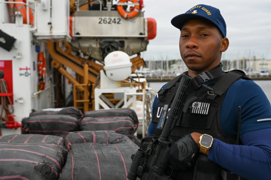 A crew member of the Coast Guard Cutter Resolute standing watch over illegal narcotics, Jan. 29, 2024, St. Petersburg, FL. Armed Coast Guardsmen stand watch over interdicted drugs to ensure security and accountability of seized contraband. (U.S. Coast Guard photo by Petty Officer 3rd Class Nicholas Strasburg)