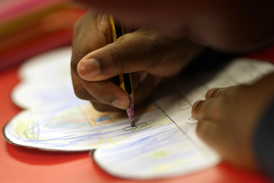 A pupil writes with a pencil during a lesson at the Holy Family Catholic Primary School in Greenwich in London, Monday, May 24, 2021. Holy Family, like schools across Britain, is racing to offset the disruption caused by COVID-19, which has hit kids from low-income and ethnic minority families hardest. (AP Photo/Alastair Grant)