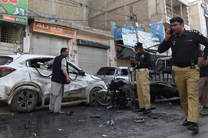 Police officers gather as they survey after a blast in Quetta