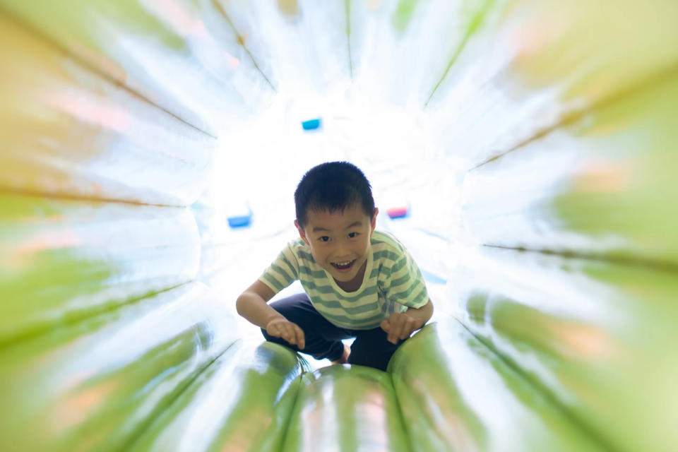 Young boy crawling through bouncy castle