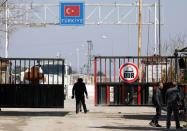 People walk at the Bab el-Salam border crossing between the Syrian town of Azaz and the Turkish town of Kilis