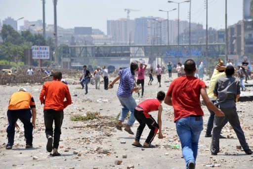 Supporters of Mohamed Morsi (foreground) clash with opponents of the ousted president in Cairo on Saturday. Egypt's political crisis deepened on Sunday, with supporters of the ousted president defiant as the National Defence Council warned it would take "decisive and firm" action if protesters overstepped