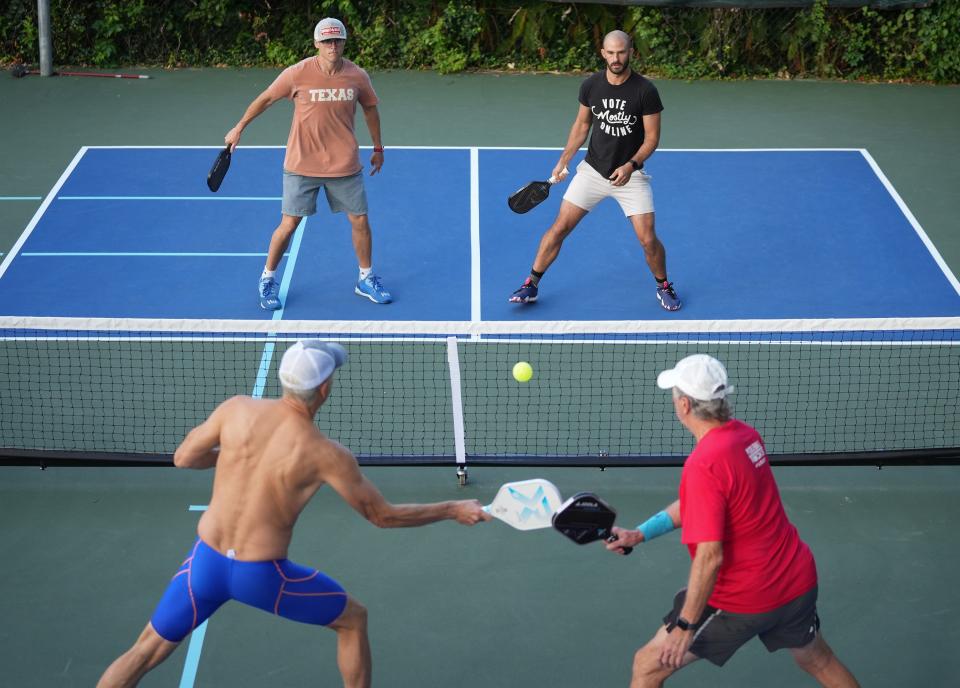 Adam Sud, top left, and Michael Fenchel play pickleball against Rip Esselstyn, bottom left, and Steve Vandegrift at the home of friend Corky Logue in Rollingwood last month. More than 50 people formed a private pickleball club that plays daily at courts in Westlake, Rollingwood and elsewhere.