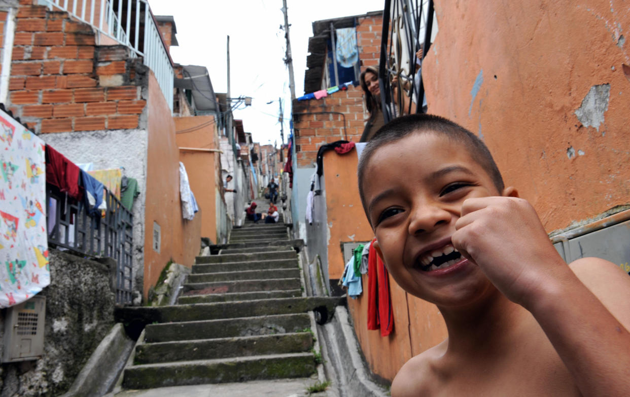 A boy smiles in the Pablo Escobar neighborhood -500 houses built by the Colombian drug lord for the poor- in Medellin, Antioquia department, Colombia on August 22, 2008. A tour operator created the 