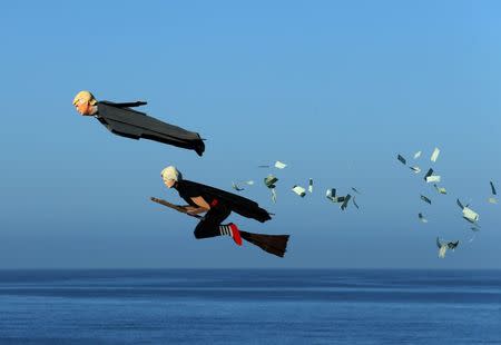 Model plane builder Otto Dieffenbach III makes his remote control plane resembling Donald Trump release fake money as it flies over the beach next to a similar plane resembling Hillary Clinton in Carlsbad, California. REUTERS/Mike Blake