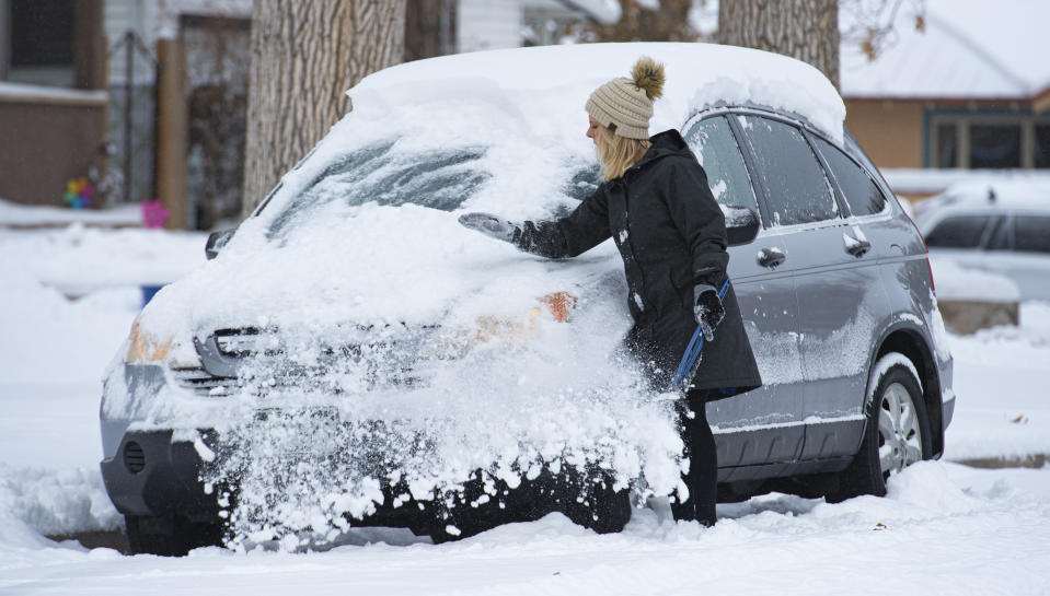 Hanne Murray clears the snow off her car before heading to work Tuesday morning, Nov. 26, 2019, in the Patty Jewett neighborhood of Colorado Springs, Colo. Downtown Colorado Springs reported about six inches of snow overnight will parts of El Paso County tallied more than a foot of snow from the storm. (Christian Murdock/The Gazette via AP)