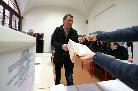 Democratic Party (PD) leader Matteo Renzi receives his ballot sheets as he prepares to cast his vote at a polling station in Florence, Italy March 4, 2018. REUTERS/Alessandro Bianchi