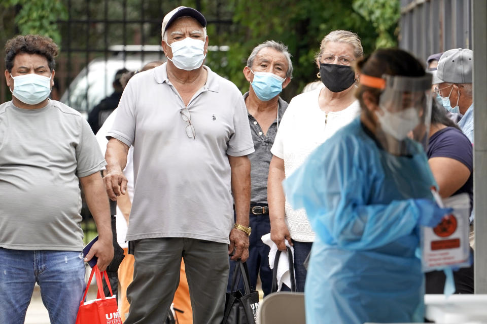 People wait in line at a free COVID-19 testing site provided by United Memorial Medical Center, at the Mexican Consulate, Sunday, June 28, 2020, in Houston. Confirmed cases of the coronavirus in Texas continue to surge. Texas Gov. Greg Abbott, on Friday, shut down bars again and scaled back restaurant dining as cases climbed to record levels after the state embarked on one of America's fastest reopenings. (AP Photo/David J. Phillip)