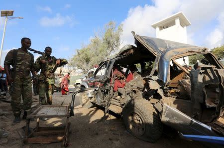 Somali policemen look at the wreckage of a car at the scene of an explosion following an attack in Somalia's capital Mogadishu, March 9, 2016. REUTERS/Feisal Omar