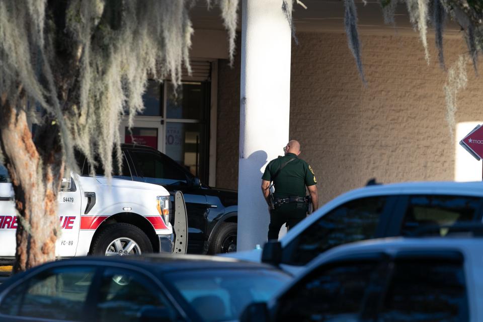 A Marion County Sheriff deputy keeps an eye on an entrance after a gunman killed one man and wounded a women at the Paddock Mall in Ocala, FL on Saturday, December 23, 2023. Ocala Police Chief Mike Balken said the shooter fled on foot.[Alan Youngblood/Ocala Star-Banner]