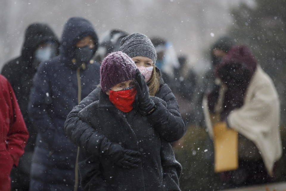 Kelly Steptoe embraces her mother Patricia Nind as they wait in line for a COVID-19 vaccination at a mass vaccination site for York Region residents 80 years and older, in Richmond Hill, Ontario, on Monday, March 1, 2021. (Cole Burston/The Canadian Press via AP)