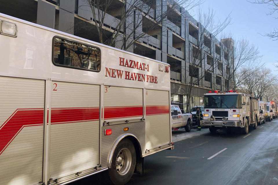 In this photo provided by New Haven CT Emergency Management Director Rick Fontana, New Haven Fire Department vehicles line a street adjacent to a Yale University-owned building where nine construction workers and five Yale employees who were renovating it were hospitalized for carbon monoxide poisoning, Wednesday, Jan. 17, 2024, in New Haven, CT. One of the workers was found lying unconscious outside of the building, which is a couple of blocks from Yale's New Haven, campus, and was taken to a hospital's hyperbaric chamber in Brooklyn, NY, where he was in critical condition. (Rick Fontana/New Haven Emergency Management via AP)