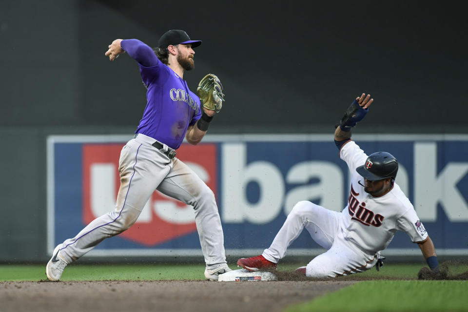 Colorado Rockies second baseman Brendan Rodger throws to first after forcing out Minnesota Twins' Luis Arraez at second during the sixth inning of a baseball game, Friday, June 24, 2022, in Minneapolis. Carlos Correa was safe at first. (AP Photo/Craig Lassig)