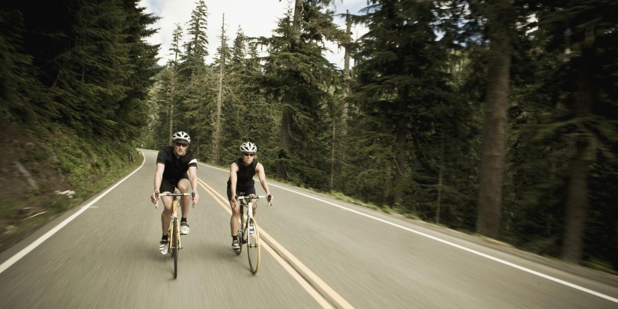 man and woman bicycling though the forest