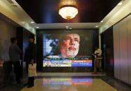 People look at a screen displaying the election results coverage on a screen inside the Bombay Stock Exchange (BSE) building in Mumbai May 16, 2014. REUTERS/Danish Siddiqui