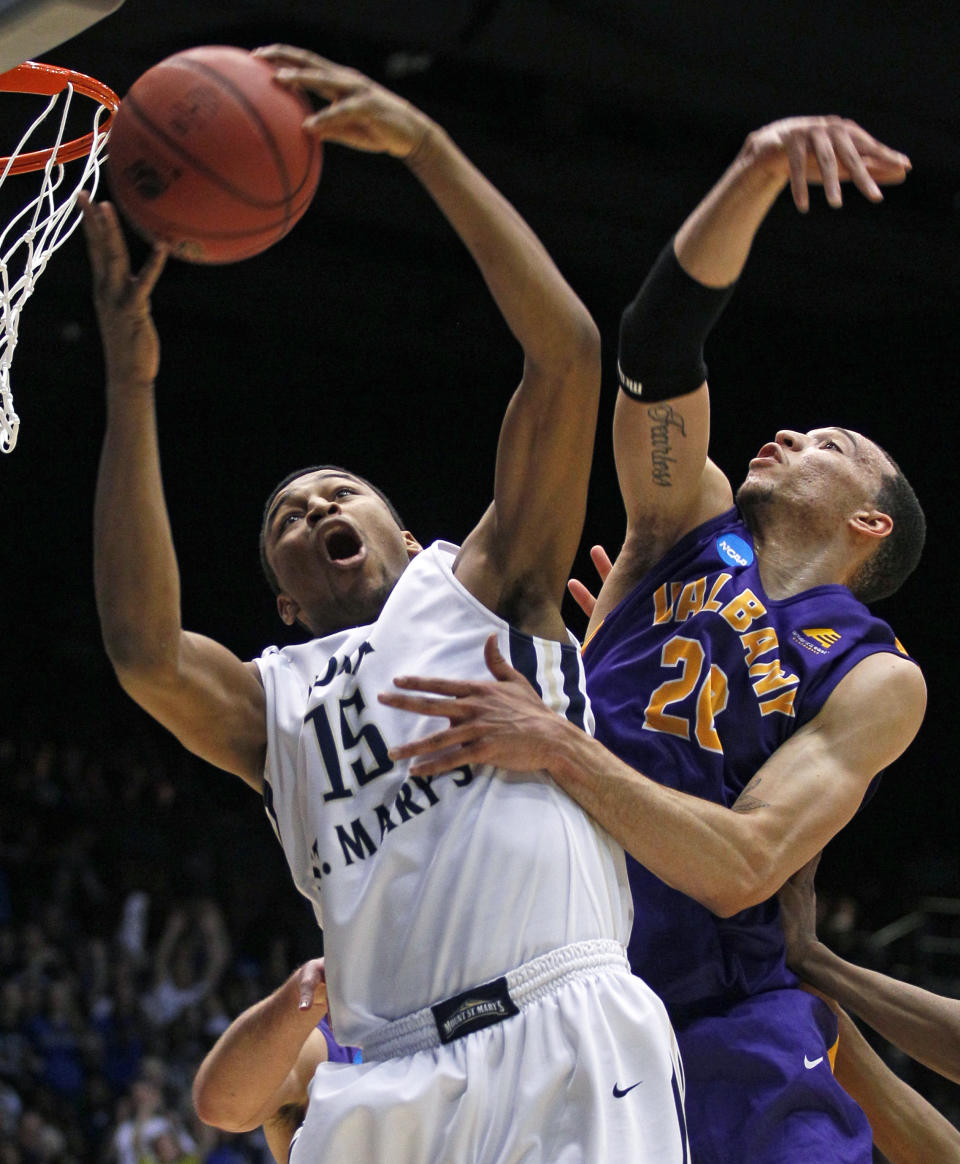 Mount St. Mary's forward Gregory Graves (15) pulls a rebound away from Albany forward Gary Johnson in the first half of a first-round game of the NCAA college basketball tournament, Tuesday, March 18, 2014, in Dayton, Ohio. (AP Photo/Skip Peterson)