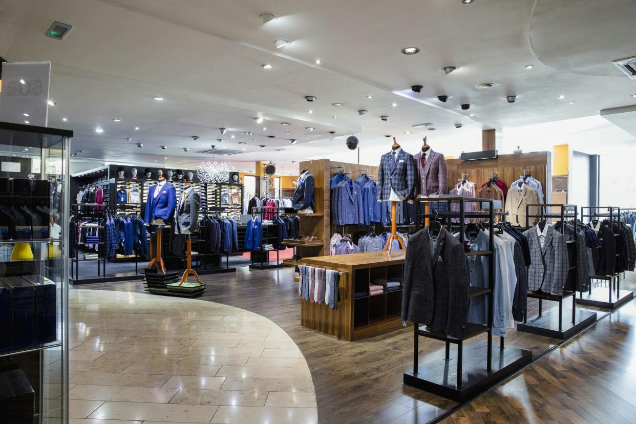 Interior of a high-quality clothing shop for men with many suits and neckties on display